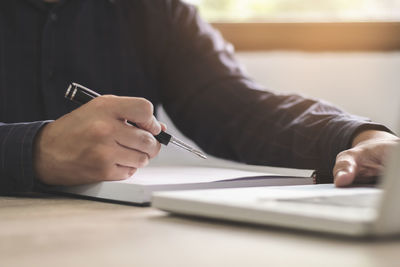 Midsection of man sitting on table