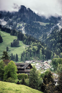 Scenic view of trees and houses by mountains