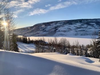 Snow covered landscape against sky