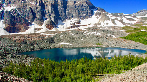 Scenic view of lake by mountains during winter