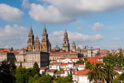 View of buildings in city against cloudy sky