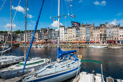 Boats moored at harbor against buildings in city