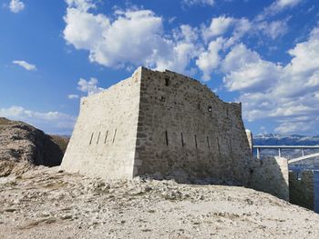 Castle by rocks against sky