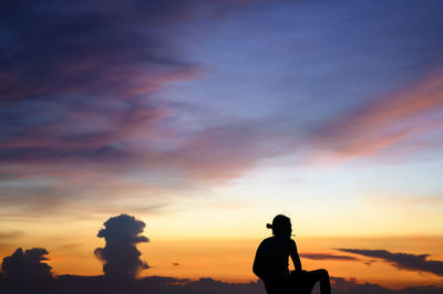 Silhouette man standing against sky during sunset