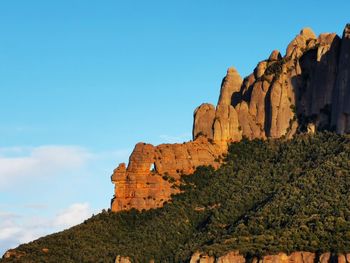 Rock formations on mountain against blue sky