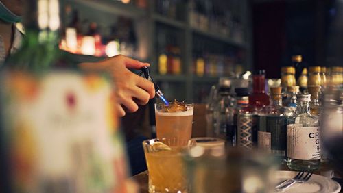 Moment of bartender burning a cocktail in bar