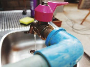 Close-up of hand with faucet in water