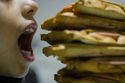 Cropped image of girl with mouth open by food