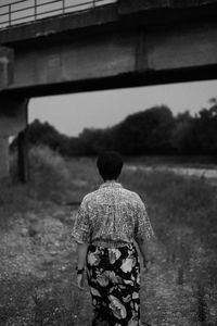 Rear view of a woman walking on under a bridge 