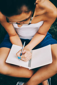 Midsection of young woman reading book