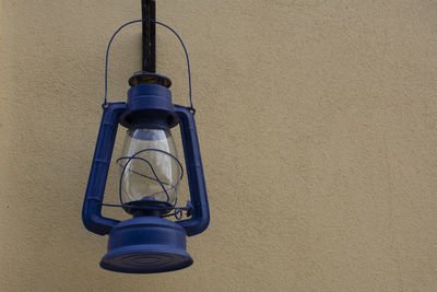 Low angle view of electric lamp against wall