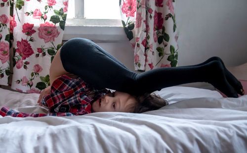 Kid exercising on bed at home