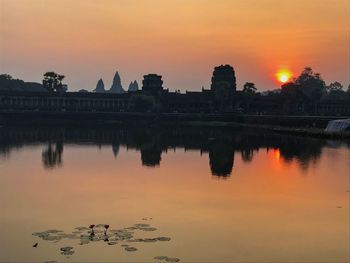 Reflection of building in lake during sunset