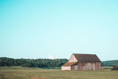 House on field against clear sky