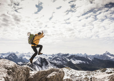 Germany, bavaria, oberstdorf, man jumping on rock in alpine scenery