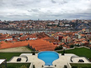 Dom luis i bridge over douro river in town against cloudy sky