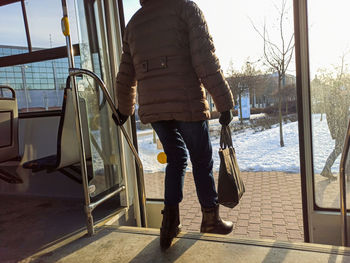 Rear view of woman standing on road in winter