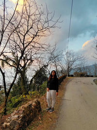 Full length portrait of man standing on road against sky