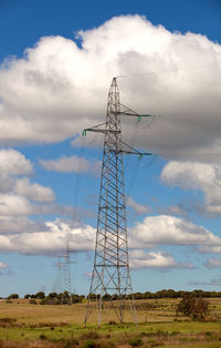 Low angle view of electricity pylon on field against sky