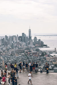 People on city buildings against sky