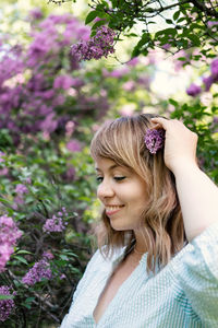 Low angle view of woman against pink flowering plants