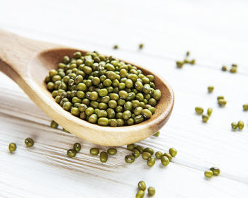 Raw mung beans in the wooden spoon on a old wooden background