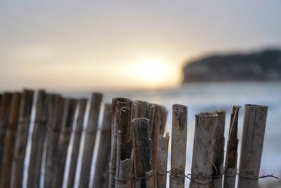 Close-up of wooden fence against sky during sunset