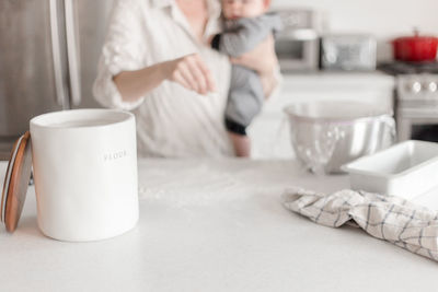 Midsection of woman using mobile phone on table