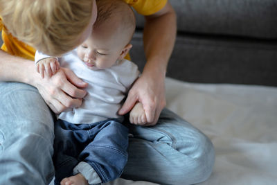 Close-up of father and son sitting at home