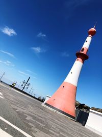 Low angle view of lighthouse by building against sky