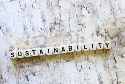 Close-up of sustainability text made from dice on wooden table