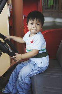 Portrait of cute boy sitting outdoors