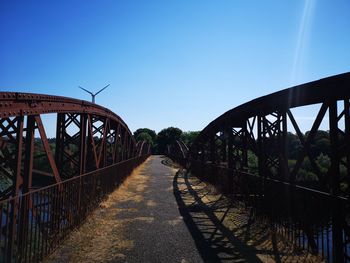 View of footbridge against clear blue sky