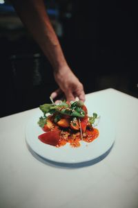 Cropped hand preparing food in restaurant