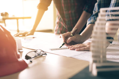 Architects discussing over blueprint at desk in office