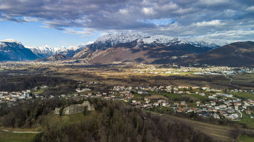 Aerial view of townscape and mountains against sky