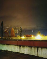 Illuminated bridge against sky at night