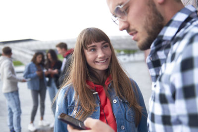 Young couple standing on mobile phone