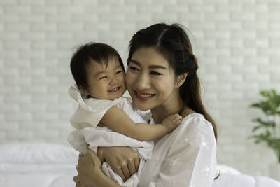 Portrait of cheerful mother with daughter at home