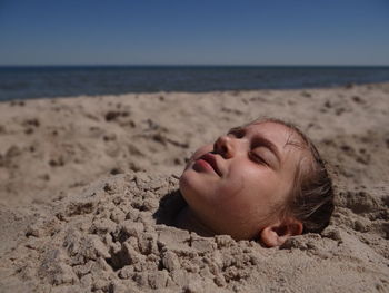 Close-up of girl sleeping on beach