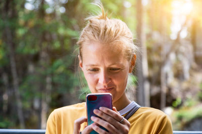Portrait of man holding smart phone outdoors