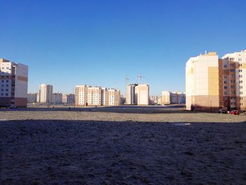 View of buildings against clear blue sky