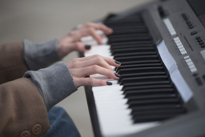 Cropped hands of woman playing piano