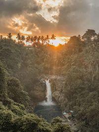 Scenic view of waterfall against sky during sunset