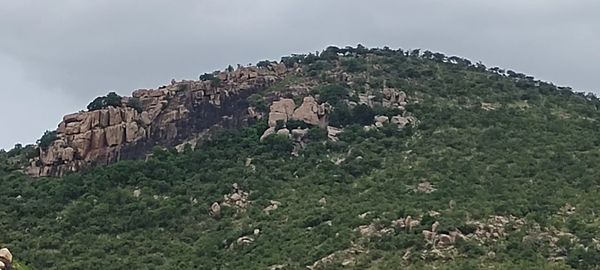 Low angle view of rocks on mountain against sky