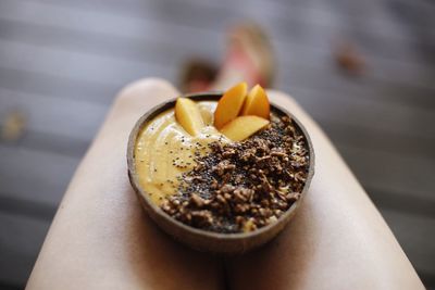 Low section of woman with food in bowl at home