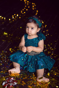 Girl in blue dress in studio with gold sequins and garland