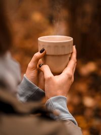 Midsection of woman holding coffee cup