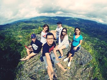 Group of people on mountain against sky