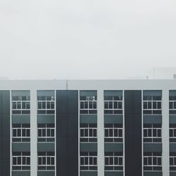 Modern building against sky during foggy weather